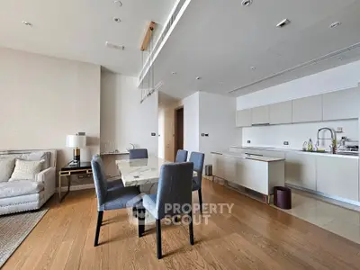 Modern open-plan living room and kitchen with elegant dining area and stylish decor.