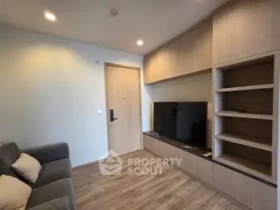 Modern living room with built-in TV unit and cozy sofa, perfect for relaxation.