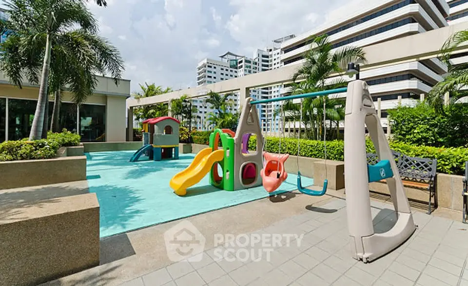 Modern condominium playground with colorful slides and swings, surrounded by lush greenery and urban skyline.