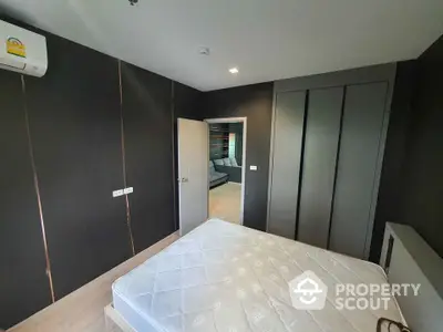 Modern bedroom with sleek dark walls and built-in wardrobe