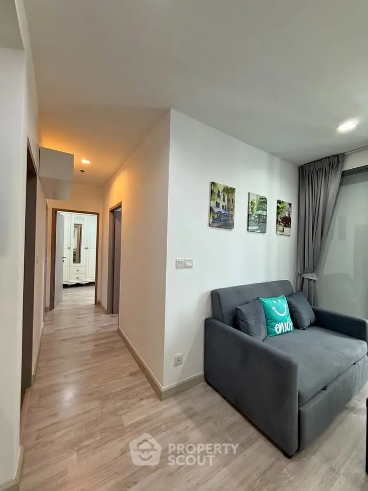 Modern apartment interior with cozy living area and hallway, featuring stylish decor and natural light.