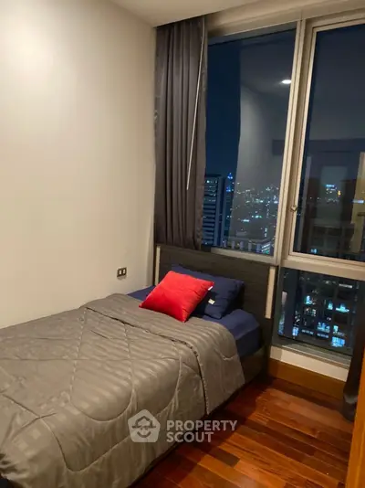 Cozy bedroom with city view, featuring a single bed and modern decor.