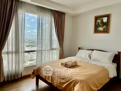 Elegant bedroom with polished wooden floors and large windows offering a panoramic city view, adorned with tasteful curtains and artwork.