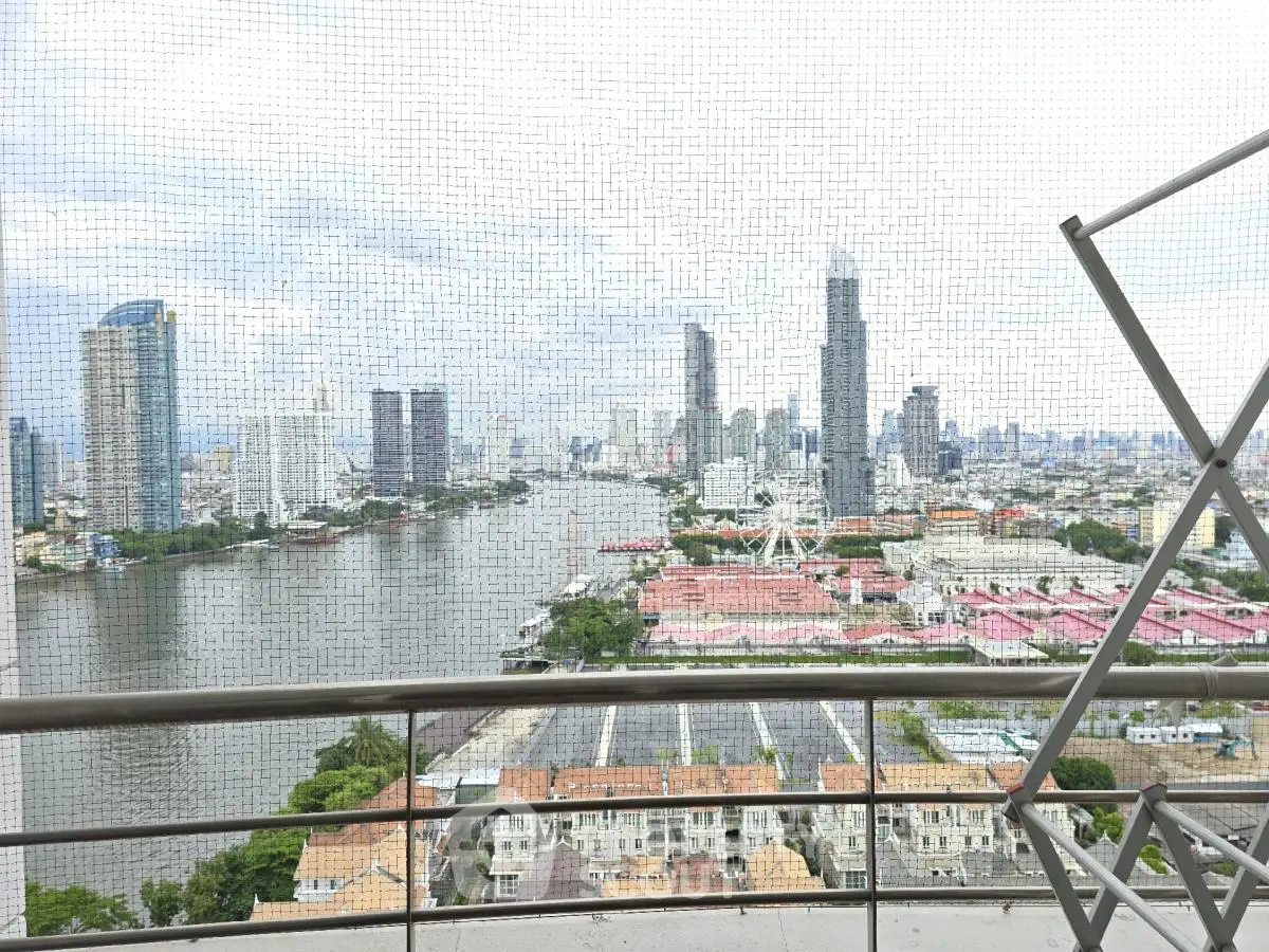 Stunning cityscape view from high-rise balcony overlooking river and skyline.
