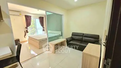 Modern studio apartment with cozy living area and bedroom, featuring sleek furniture and natural light.