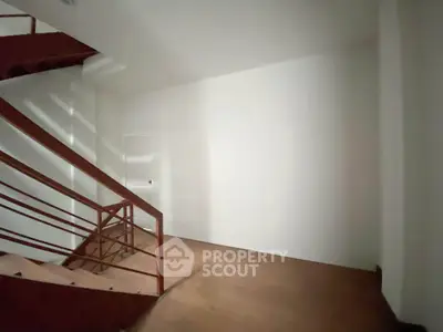 Spacious modern staircase with sleek wooden railing and minimalist design
