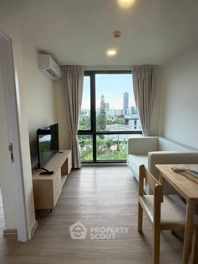 Modern living room with city view, featuring sleek furniture and large windows for natural light.