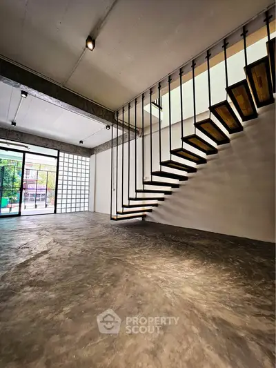 Modern industrial loft with floating staircase and large windows