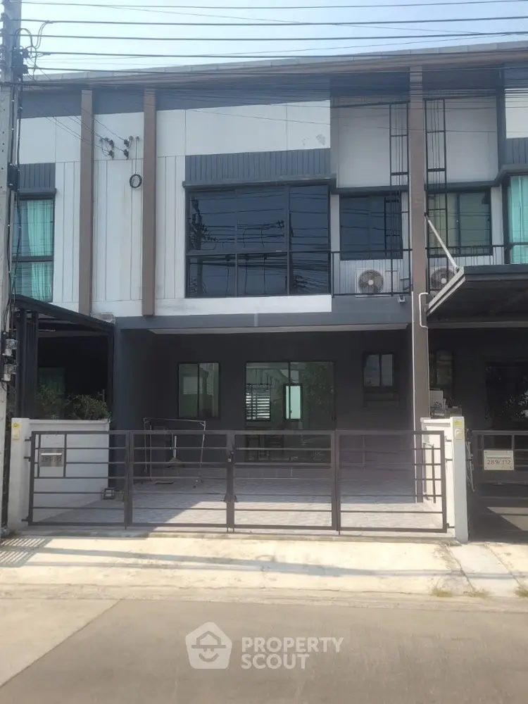 Modern townhouse exterior with sleek design and large windows in urban setting.