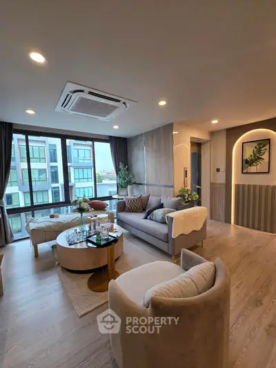 Luxurious modern living room with elegant decor and large windows offering a stunning view.