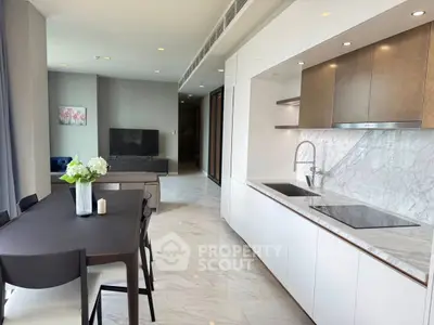 Modern open-layout kitchen and dining area with sleek design and marble finishes.
