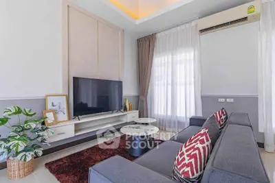 Modern living room with stylish decor, large TV, and comfortable seating in a bright, airy space.
