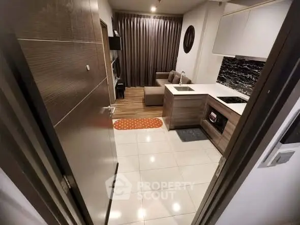 Modern apartment with open kitchen and cozy living area, featuring stylish decor and sleek finishes.