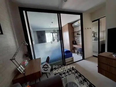 Modern bedroom with glass partition and study area, featuring sleek furniture and stylish decor.