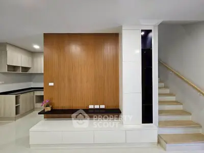 Modern interior with sleek staircase and stylish wooden paneling, perfect for contemporary living.