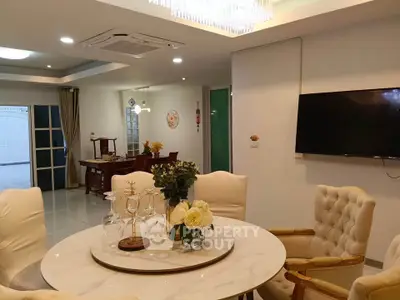 Elegant dining area with marble table and plush chairs in a modern open-plan living space.