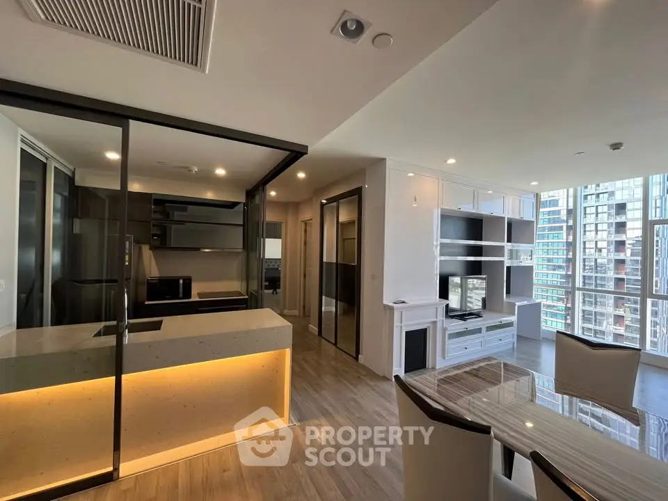 Modern open-plan living room and kitchen with sleek design and city view.
