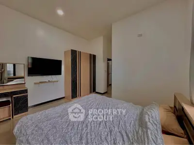 Modern bedroom with stylish furniture and wall-mounted TV, perfect for comfort and relaxation.