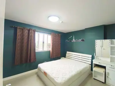 Spacious bedroom with modern decor and ample natural light, featuring a comfortable bed and stylish furniture.