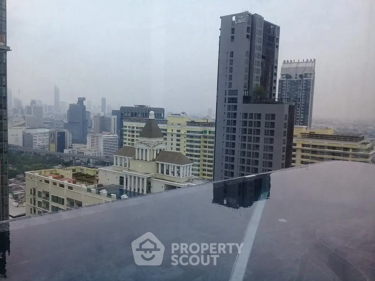 Stunning cityscape view from rooftop infinity pool in modern urban high-rise.