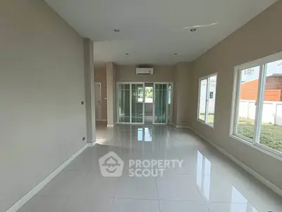 Spacious modern living room with large windows and sleek tile flooring