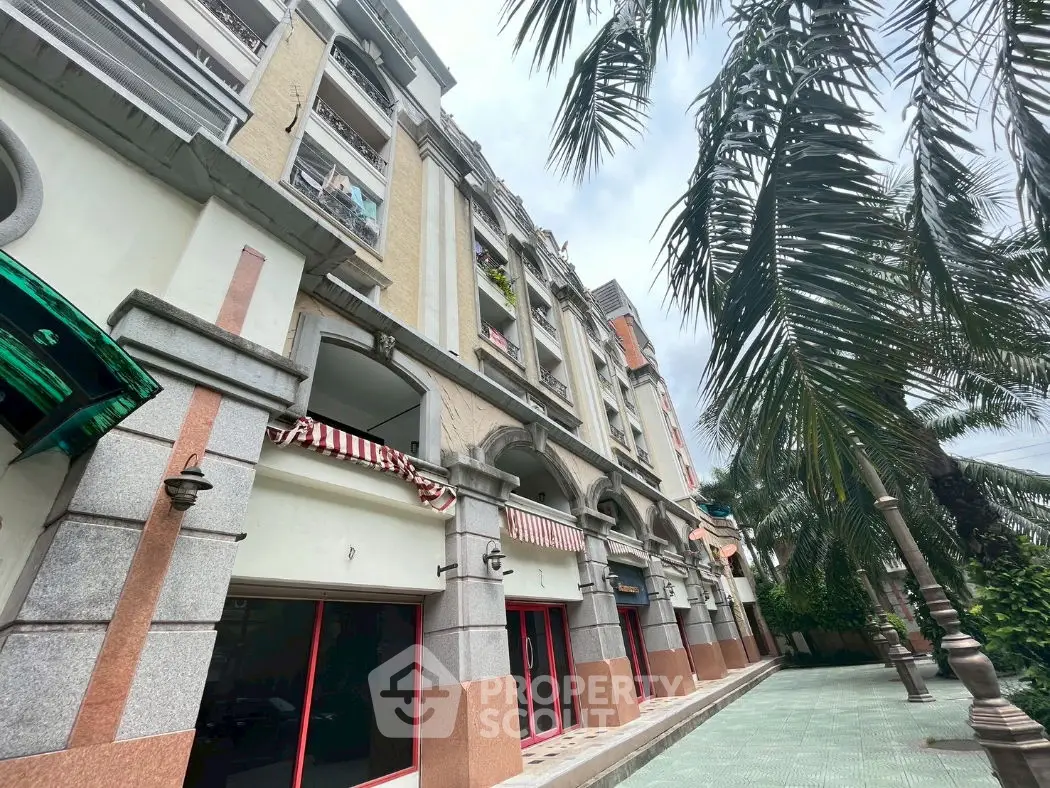 Elegant multi-story building with palm trees and stylish facade