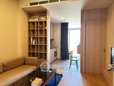 Modern living room with wooden furniture and open layout, featuring a cozy sofa and stylish shelving.