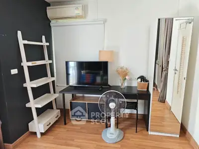 Modern living room with sleek TV stand, ladder shelf, and stylish decor in a cozy apartment.