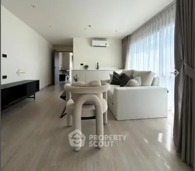 Spacious modern living room with elegant furniture and large windows for natural light.