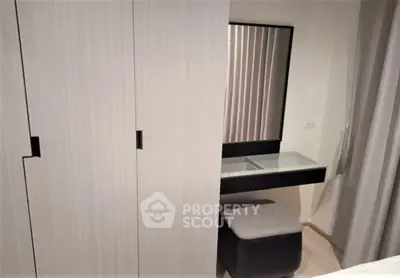 Modern bedroom with sleek wardrobe and stylish vanity area