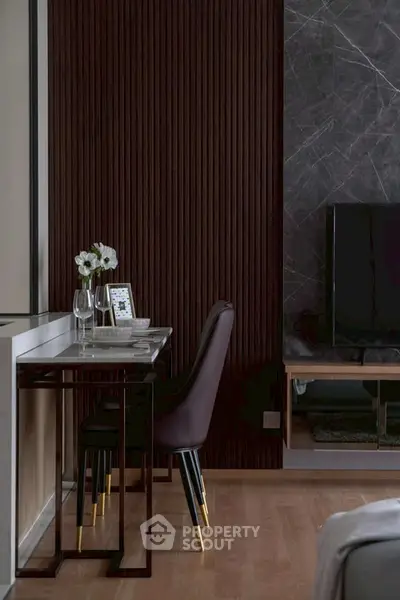 Modern living room with elegant decor and stylish furniture, featuring a sleek TV setup and cozy dining area.