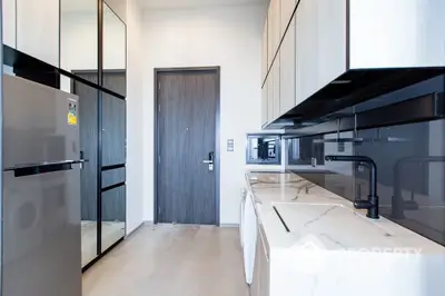 Modern kitchen with sleek cabinetry and marble countertops in a stylish apartment.