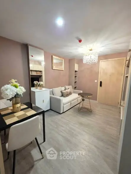 Stylish living room with modern decor and elegant chandelier in cozy apartment.