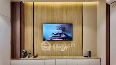 Modern living room with stylish wooden paneling and mounted TV, perfect for cozy entertainment.