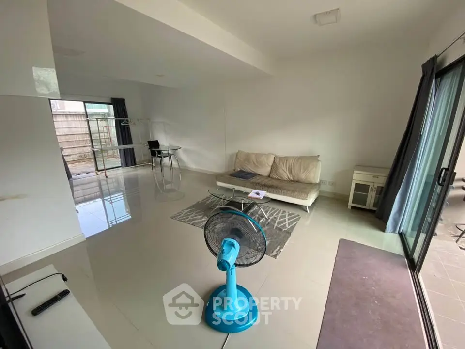 Spacious living room with modern furniture and sliding glass doors leading to a patio.