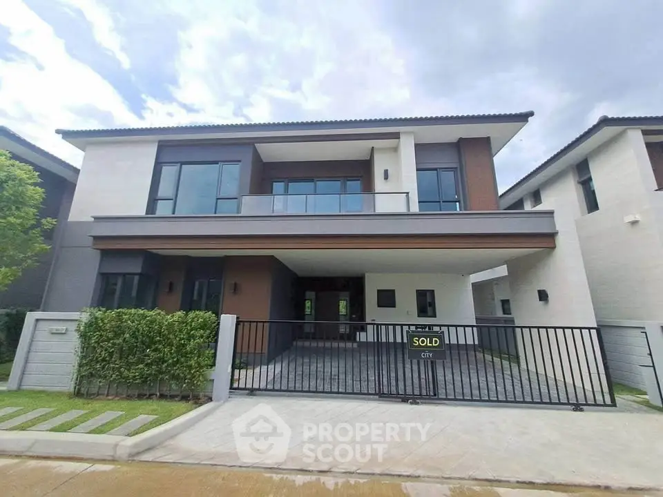 Modern two-story house with sleek design and spacious driveway in a serene neighborhood.