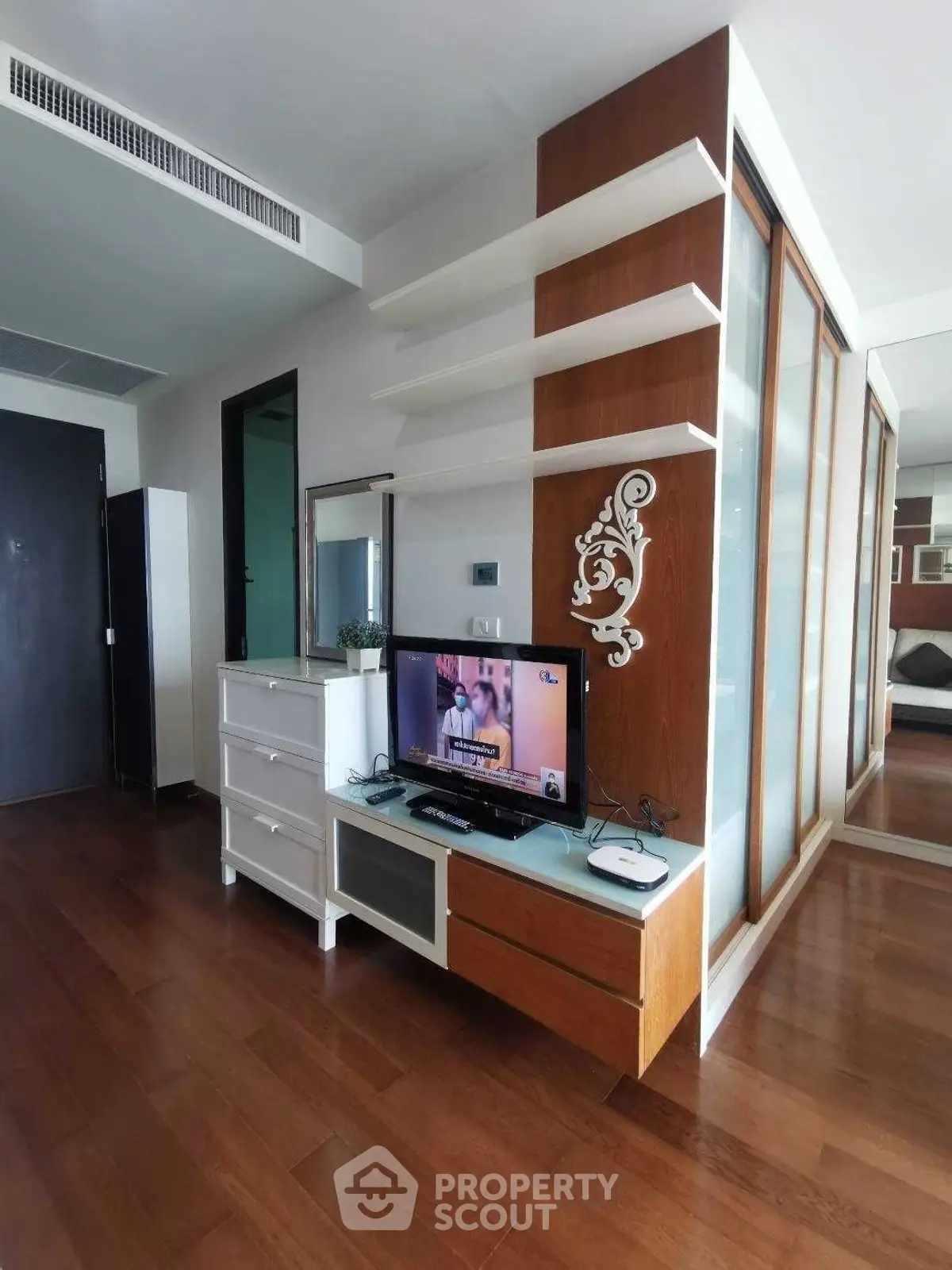 Modern living room with stylish wooden flooring and sleek TV unit