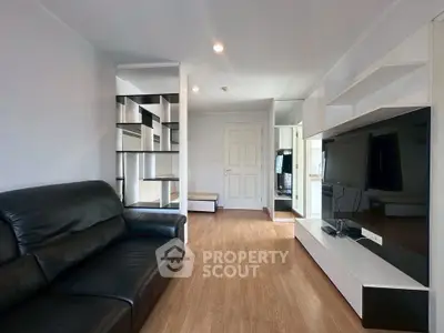 Modern living room with sleek black leather sofa and built-in shelving