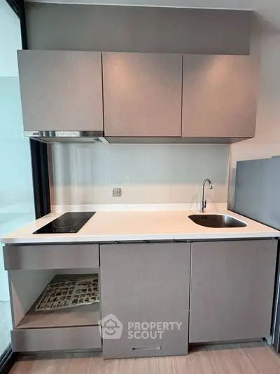 Modern compact kitchen with sleek cabinetry and built-in appliances