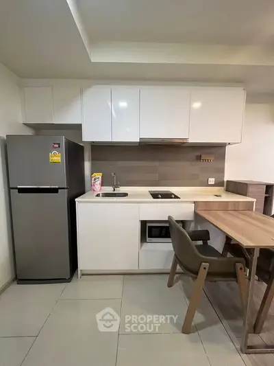 Modern kitchen with sleek cabinetry and integrated appliances in a compact layout.