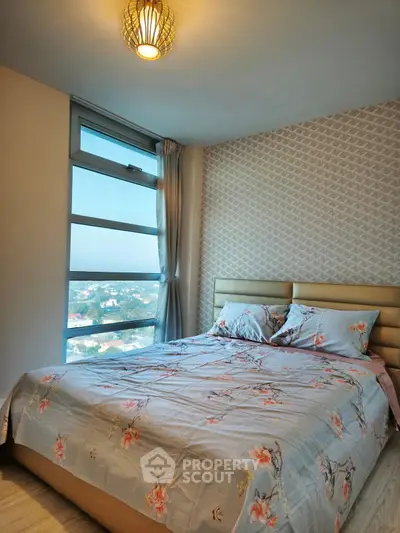 Cozy bedroom with large window offering stunning city views and elegant decor.