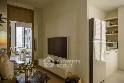 Modern living room with sleek TV setup and adjacent kitchen area in stylish apartment.