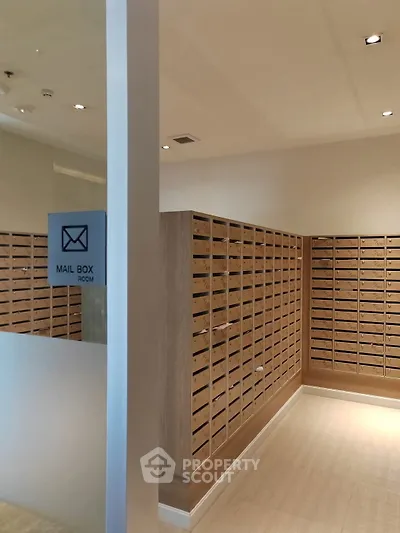 Modern mailbox room with sleek wooden mail slots and bright lighting.