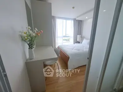 Bright and cozy bedroom with modern decor and large window view.