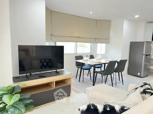 Modern living room with dining area and TV, bright and inviting space.