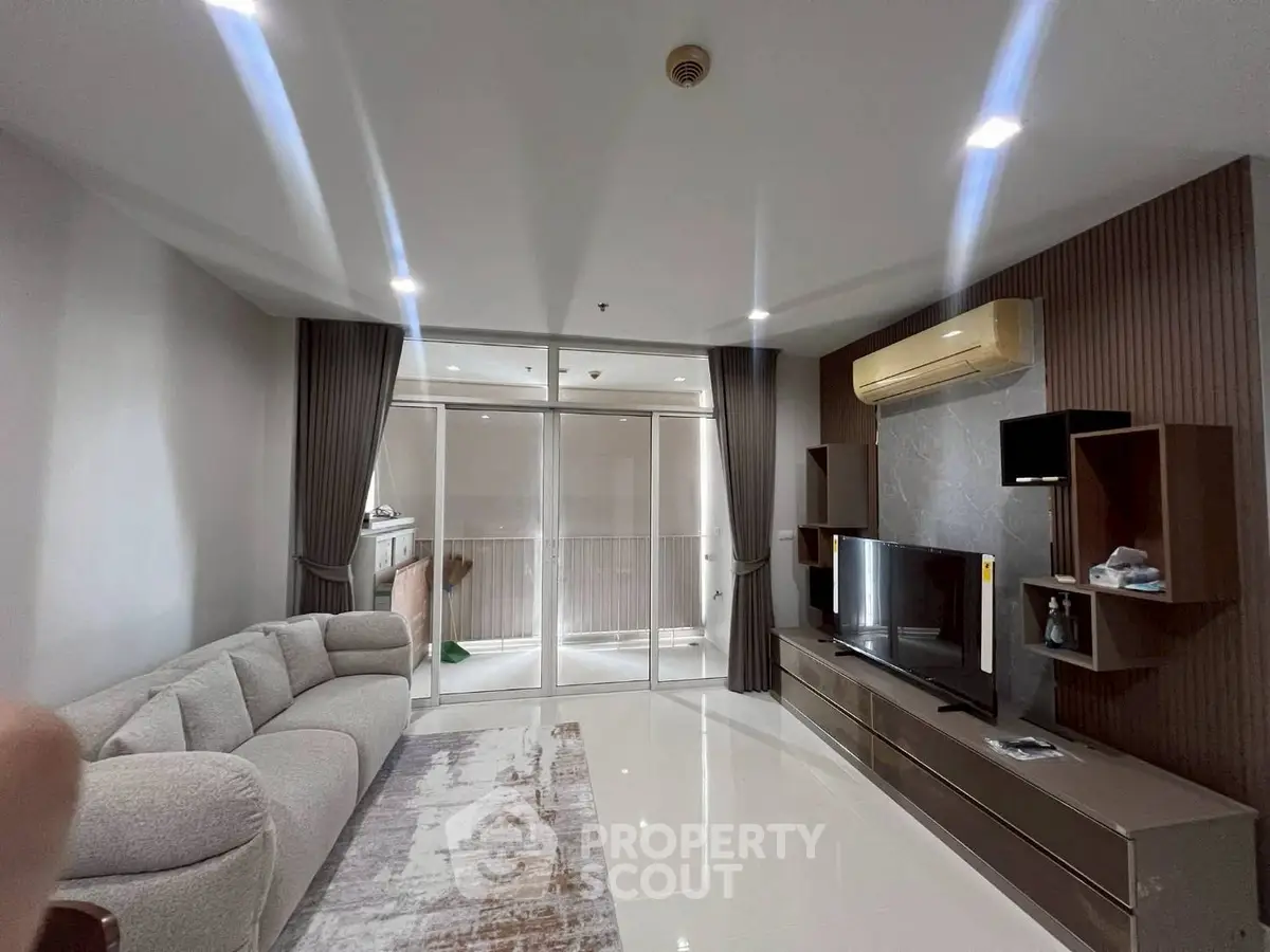Modern living room with sleek design and balcony access in a stylish apartment.