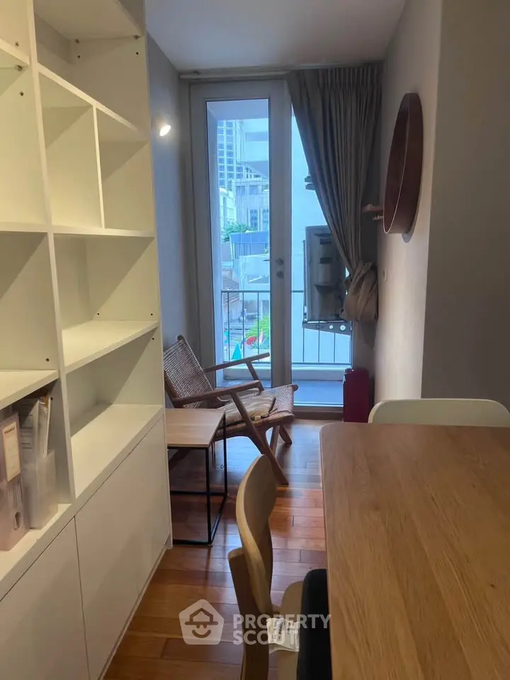 Charming living room with wooden floors, modern furniture, and a balcony view in a cozy apartment.