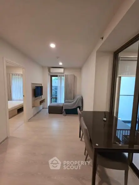 Modern living room with sleek furniture and large windows offering natural light.