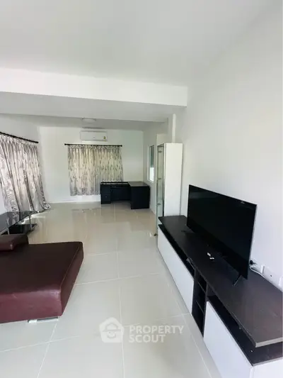 Spacious living room with modern furniture and large windows for natural light.