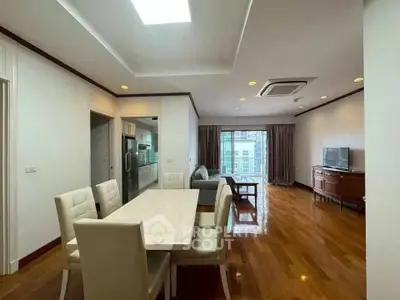 Spacious open-plan living and dining area with modern furnishings and wooden flooring.